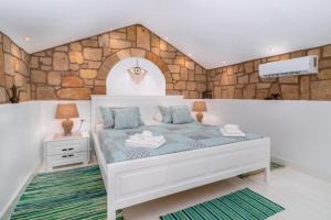1 dormitorio con cama y pared de piedra en Koskinou Traditional Houses, en Koskinou
