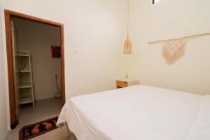 a bedroom with a white bed and a mirror at Villa Sakinah Private Pool by Masterpiecevilla in Batu
