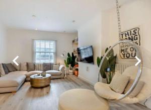 uma sala de estar com um sofá e uma mesa em Stunning 2 bedroom flat Camden em Londres