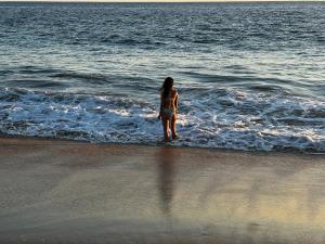 Una donna in piedi sull'acqua della spiaggia di Condominio Agave del Mar a Coyuca