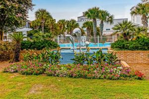 a fountain with swans in a park with flowers at Baytowne Wharf - Pilot House #207 in Destin