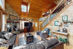 ein Wohnzimmer mit Sofas und einer Treppe in einer Hütte in der Unterkunft Buckhorn in Sautee Nacoochee