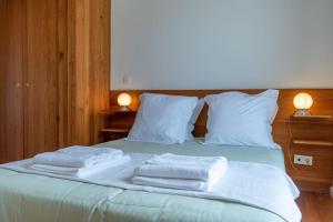 Una cama con tres toallas encima. en The Escape en Ponta Delgada