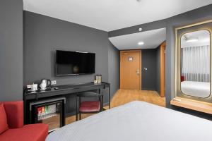 um quarto de hotel com uma cama e uma televisão em Ibos Hotels Izmir Alsancak em Alsancak