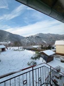 uma vista para um pátio coberto de neve a partir de uma varanda em Burgener Burgblick em Burgen