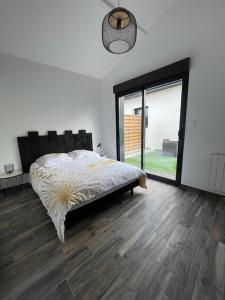 um quarto com uma cama e uma grande janela em Jolie maison dans un quartier très calme em Martignas-sur-Jalle