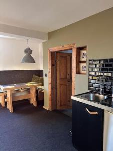 uma cozinha com um lavatório, uma mesa e uma porta em Urban Apartments Weimarer Land em Buttelstedt