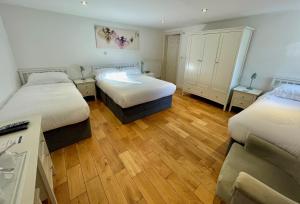 a bedroom with two beds and a wooden floor at The Queen's Head Hotel in Buxton