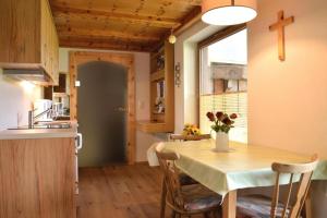 una cocina con una mesa con un jarrón de flores. en Haus Kohler, en Häselgehr