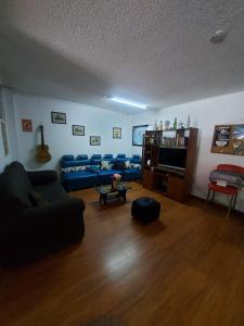 uma sala de estar com um sofá e uma televisão em North House Hostel em Bogotá