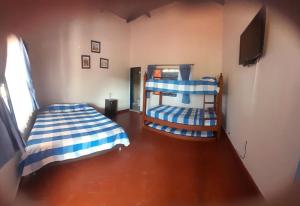 a bedroom with two bunk beds and a flat screen tv at Finca Cafetera Las Mercedes in Cumaca