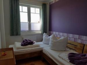 a bedroom with two beds with pillows and a window at Muschelsucher - Sünnenkieker WE10 - ABC250 in Beckerwitz