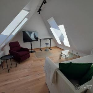a attic living room with a couch and a tv at Jogilation in Sankt Jakob im Walde