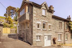 an old brick house with white doors and windows at Langdale Boulders, Ambleside, Fantastic views in Chapel Stile
