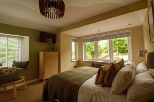 a bedroom with a large bed and two windows at Langdale Boulders, Ambleside, Fantastic views in Chapel Stile