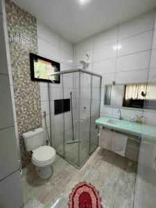 y baño con ducha, aseo y lavamanos. en Casa para locação no período da Tecnoshow Comigo 2024, en Rio Verde