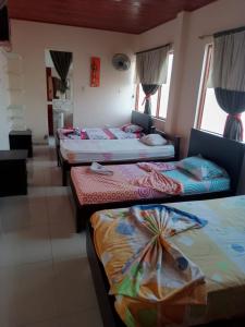 a group of four beds in a room at Samantha Hotel in Paz de Ariporo