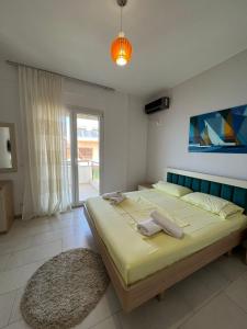 een slaapkamer met een groot bed en een groot raam bij The Blue Horizon in Vlorë