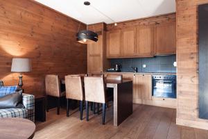 a kitchen with wooden cabinets and a table and chairs at Vestlia Resort in Geilo
