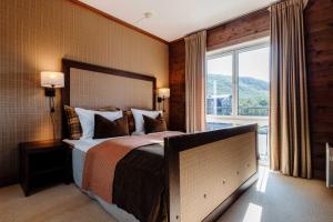 a bedroom with a large bed and a large window at Vestlia Resort in Geilo