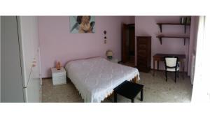 a bedroom with a bed and a table and a chair at Maria's Apartment in Pesaro