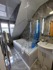 y baño con ducha, bañera y lavamanos. en Shandon Bells Guest House en Cork