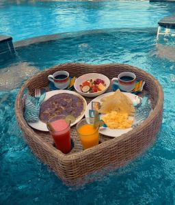 a table of food in a basket in the water at Meket Bungalows in Nusa Penida