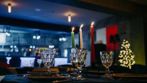 stół z czterema kieliszkami i świecami w obiekcie Hotel Sapphire Bakuriani w mieście Bakuriani