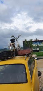 a bike on the roof of a yellow car at Bicycle House in Felgueiras