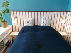 um quarto com uma cama azul e duas mesas em Isensee - ABC322 em Wismar