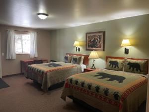 a hotel room with two beds and a window at Antlers Lodge in Cooke City