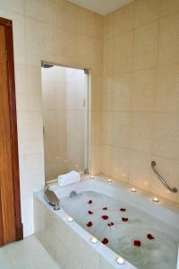 una vasca da bagno con petali di rosa rossa di Hotel Cityzen Guayaquil a Guayaquil
