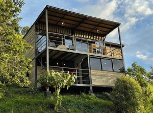 a house on a hill with a lot of windows at Magma Home Cabaña Loft - Guatape Piscina-Jacuzzi in El Peñol