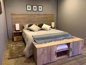 um quarto com uma cama grande e uma cabeceira em madeira em Magma Home Cabaña Loft - Guatape Piscina-Jacuzzi em El Peñol
