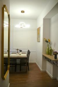 a dining room with a table and a mirror at Goldengreen Apartment in Kraków