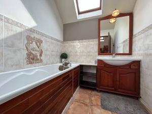 y baño con bañera, lavabo y espejo. en 520 - Appartement T3 en duplex en plein cœur d'Erquy, en Erquy