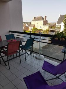 uma varanda com cadeiras roxas e uma mesa na varanda em 523 - A ERQUY, proximité centre ville et plage du centre, dans un immeuble tranquille em Erquy