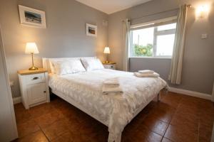 una camera da letto con un letto e due asciugamani di Summerfield Lodge Garden Cottage a Youghal