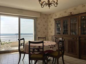 Un comedor con mesa y vista al mar. en 513 - Appartement T3 avec pleine vue mer, en Erquy