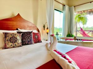 una habitación de hotel con una cama con pies en ella en BANGATACHO - Bangalôs Temáticos na Praia do Patacho - Milagres en Pôrto de Pedras