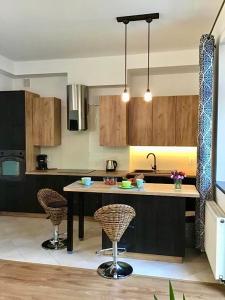 a kitchen with a table and two bar stools at Goldengreen Apartment in Kraków