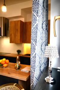 a kitchen with a table with a blue and white curtain at Goldengreen Apartment in Kraków
