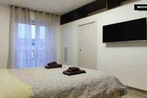 ein Schlafzimmer mit einem Bett mit zwei braunen Handtüchern darauf in der Unterkunft De Angeli District in Mailand