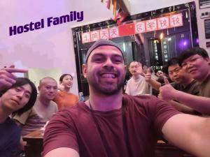 a man sitting in front of a group of people at Riverside International Youth Hostel in Chongqing