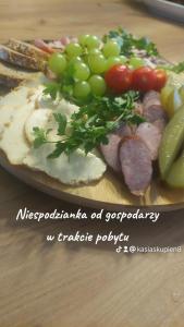 a plate of food with grapes and meat and vegetables at Domek Dream Holiday in Poronin