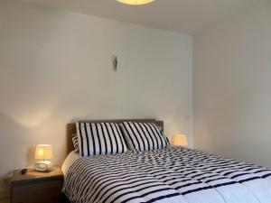 una camera da letto con un letto con due lampade sopra di 534 - Maison 3 chambres en plein centre d'Erquy, à proximité de toutes commodités a Erquy
