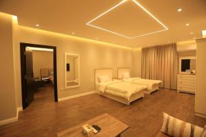 een grote slaapkamer met twee bedden en een kamer met een tafel bij Munir`s residence 2 in Caïro +252 foto's