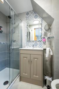a bathroom with a shower and a sink and a mirror at Summerfield Lodge B&B in Youghal