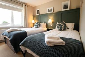 1 dormitorio con 2 camas y toallas. en Summerfield Lodge B&B, en Youghal