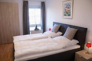 un grande letto con lenzuola bianche in una camera da letto di Lübsche Burg - ABC248 a Wismar